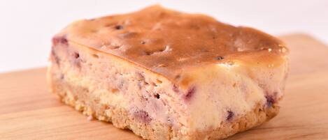 A single slice of cake on a wooden surface.