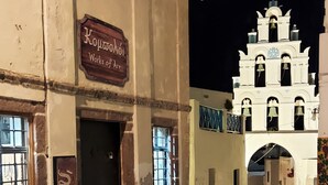 A cobblestone street leading to a white church with a bell tower. - Traditional Village House 'Alba Lily' with heated plunge pool (Megalochori)