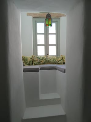 A narrow stairwell with a bench at the top and a hanging lantern. - Traditional Village House 'Alba Lily' with heated plunge pool (Megalochori)