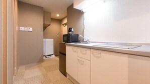 A modern kitchen with white cabinets, a microwave, and a coffee maker.