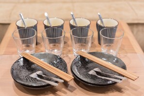 A table with six small glasses and two plates with chopsticks and spoons. - Stay SAKURA Kyoto Nijo Seasons (Kyoto)