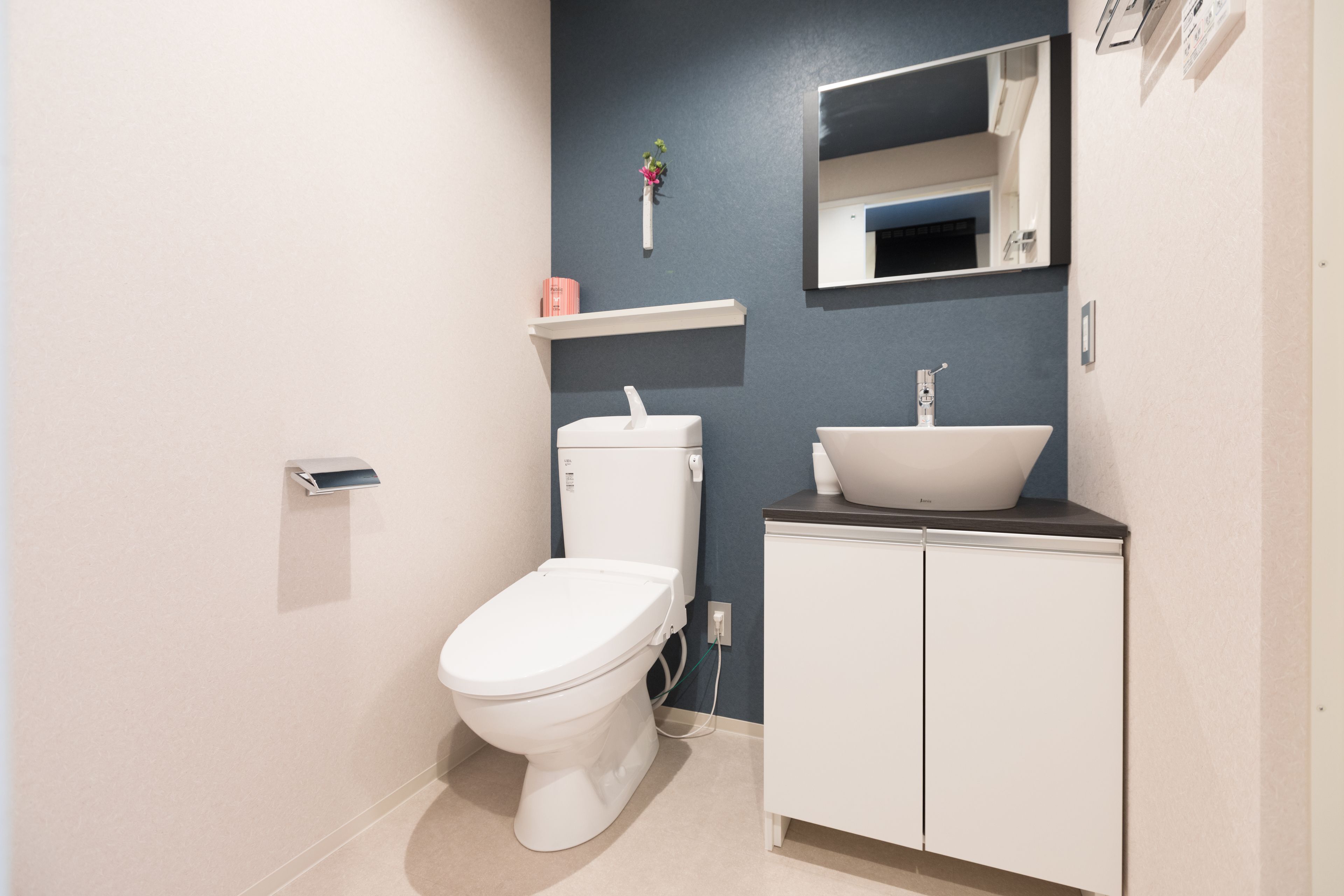 Un baño moderno con inodoro, lavamanos y espejo.