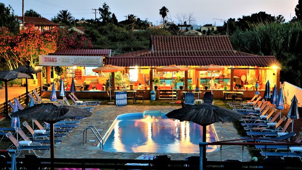 A poolside area with lounge chairs and umbrellas, a bar with outdoor seating, and a sign for 'STARS BAR RESTAURANT'. - Stars Hotel - Adults Only (Corfu)