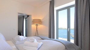A hotel room with a bed, a lamp, and a view of the sea. - Ohlerich storage app. 34 - Ohlerich Speicher App. 34 (Wismar)