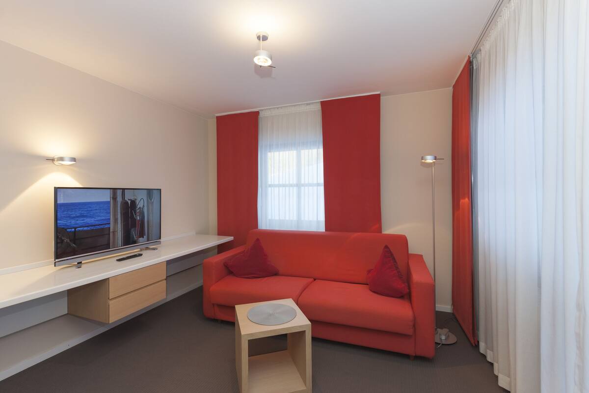 Appartement, terras | Woonruimte | Een 32-inch flatscreentelevisie met satellietzenders en televisie