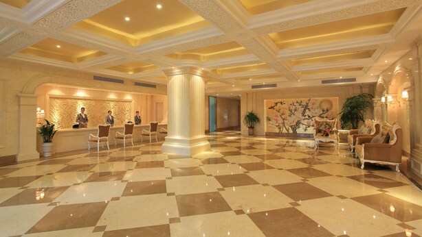 A spacious lobby with a checkered floor, a reception desk, and seating areas. - Zhuhai Rongfeng Hotel (Zhuhai)