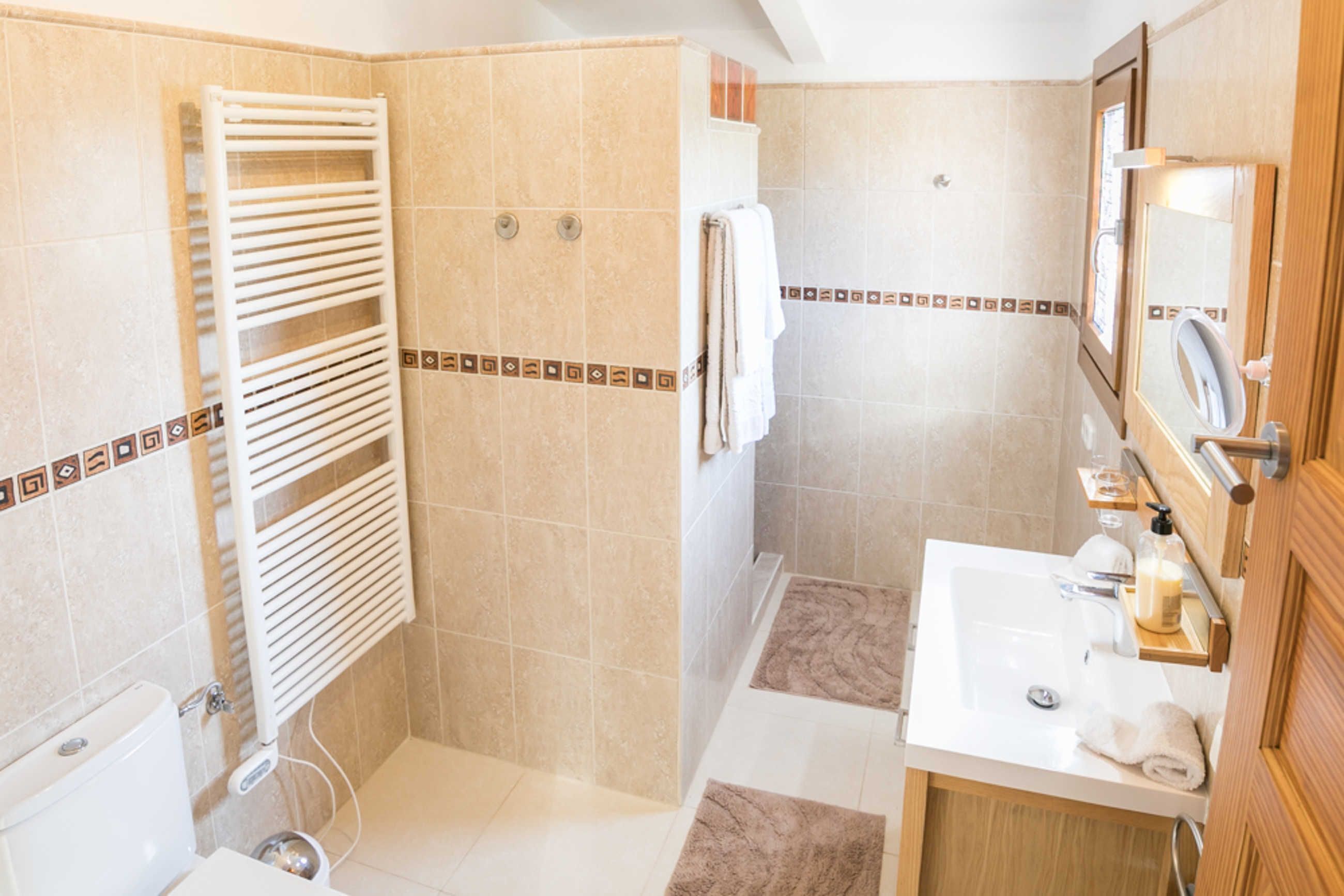 Ein Badezimmer mit Dusche, Waschbecken und Toilette.