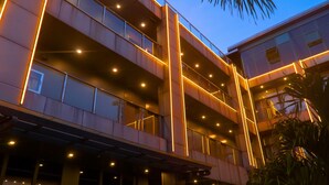 A multi-story building with a modern design, featuring a series of balconies and a covered walkway.