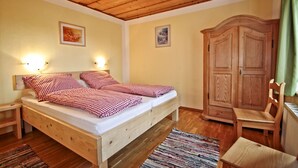 Ein Schlafzimmer mit einem hölzernen Bett, zwei Nachttischen, einem Schrank aus Holz und einem Stuhl.