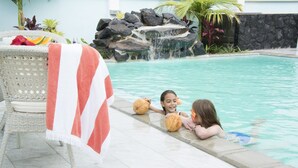 Zona de piscina con una silla de mimbre y una toalla.