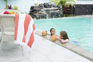 Una piscina al aire libre, sillones reclinables de piscina