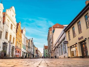 Une rue pavée bordée de bâtiments historiques, dont un hôtel-boutique dont l’enseigne est bien visible.