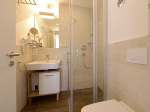 A modern bathroom with a glass-enclosed shower, a white sink, and a toilet. - Ohlerich storage app. 36 - Ohlerich Speicher App. 36 (Wismar)