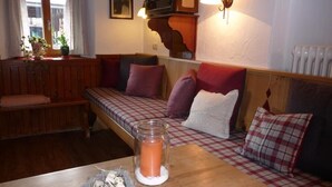 A cozy room with a checkered sofa, a wooden table, and a vintage radio. - Apartment Geigelstein for 2 pers., 36 sqm, balcony (Schleching)