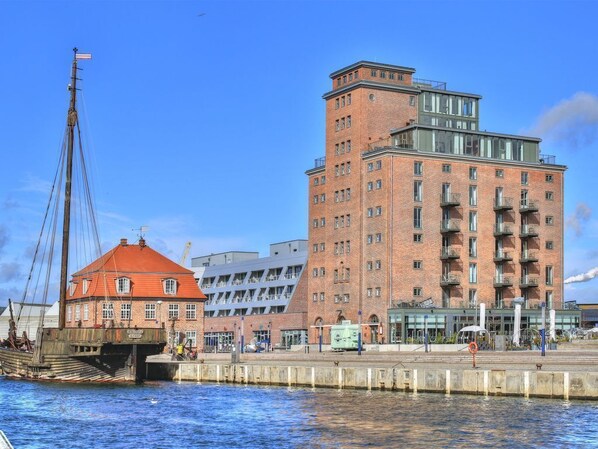 A waterfront building with a red brick facade and a modern glass extension.