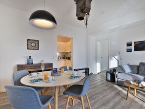 Un salon moderne comprenant un coin repas, un canapé et une table basse.