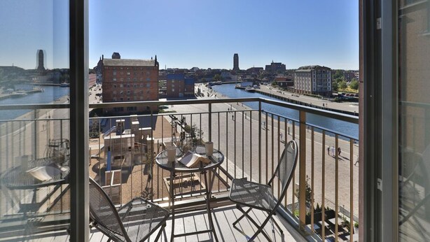 En balkon med udsigt over bybilledet og en flod.