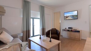 A modern living room with a sofa, a coffee table, a TV, and a cabinet. - Ohlerich storage app. 41 - Ohlerich Speicher App. 41 (Wismar)