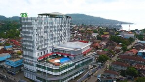 Een modern hotel met een uniek architectonisch ontwerp, met een opvallend verticaal element en een zwembad op het dak.