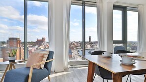 A modern room with a large window, a dining table, and a blue chair.