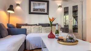 A modern living room with a sofa set, a coffee table with decorative items, and a framed picture on the wall.