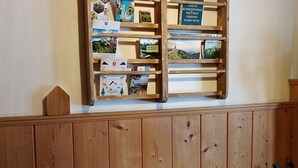 A wooden shelf with books and a small wooden house model. - Ferienwohnung Nr 1,  2 Pers. 50 qm (Schleching)