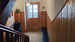 A wooden staircase leading to a room with a door that has frosted glass panels. - Ferienwohnung Nr 1,  2 Pers. 50 qm (Schleching)