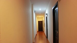 A narrow hallway with a tiled floor and a door at the end. - K&J Apartment (Pattaya)