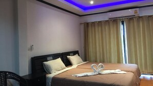 A hotel room with a bed, a desk, and a chair. - K&J Apartment (Pattaya)