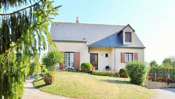 A two-story house with a sloped roof, a front porch, and a well-maintained lawn. - Quiet cottage near Azay-le-Rideau Castle (Azay-le-Rideau)