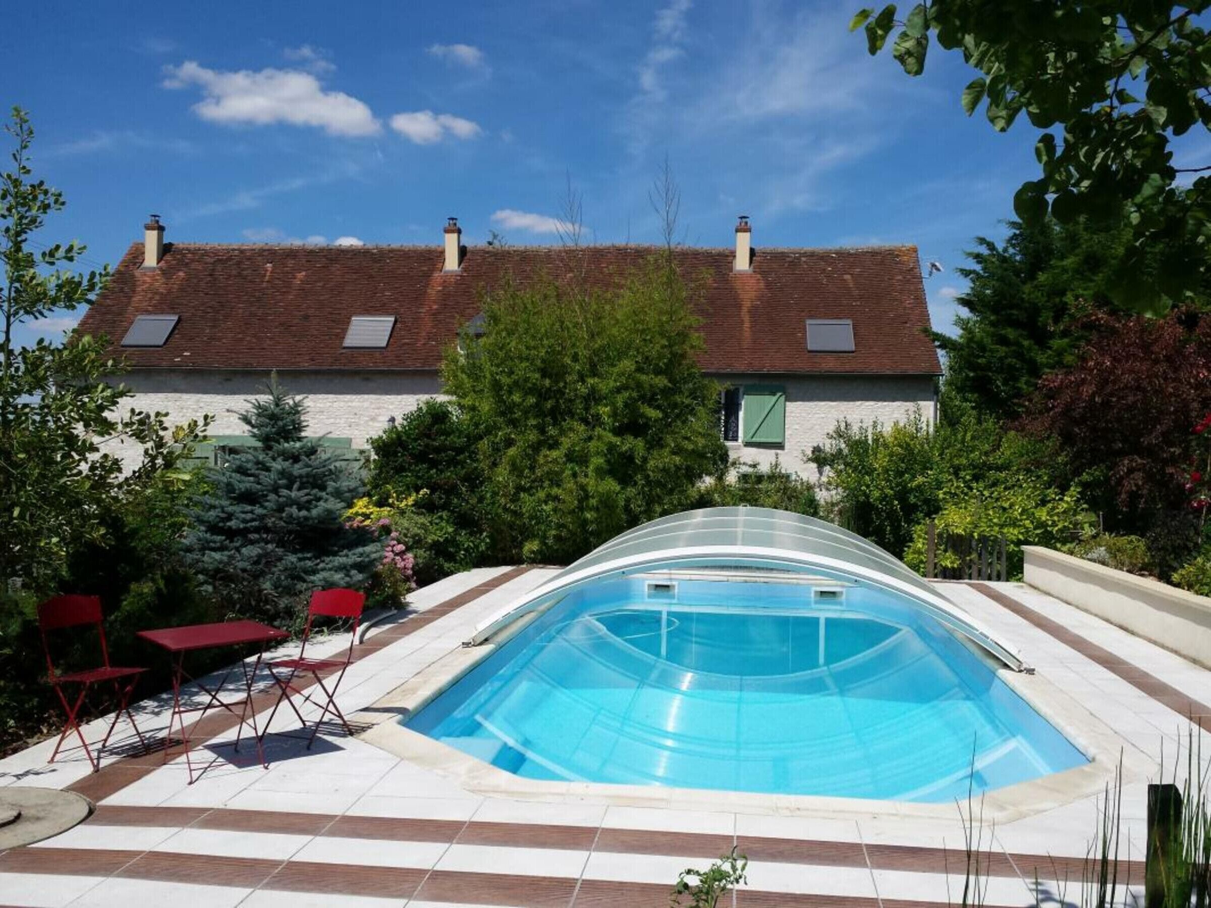 A swimming pool with a curved edge, surrounded by a tiled deck.