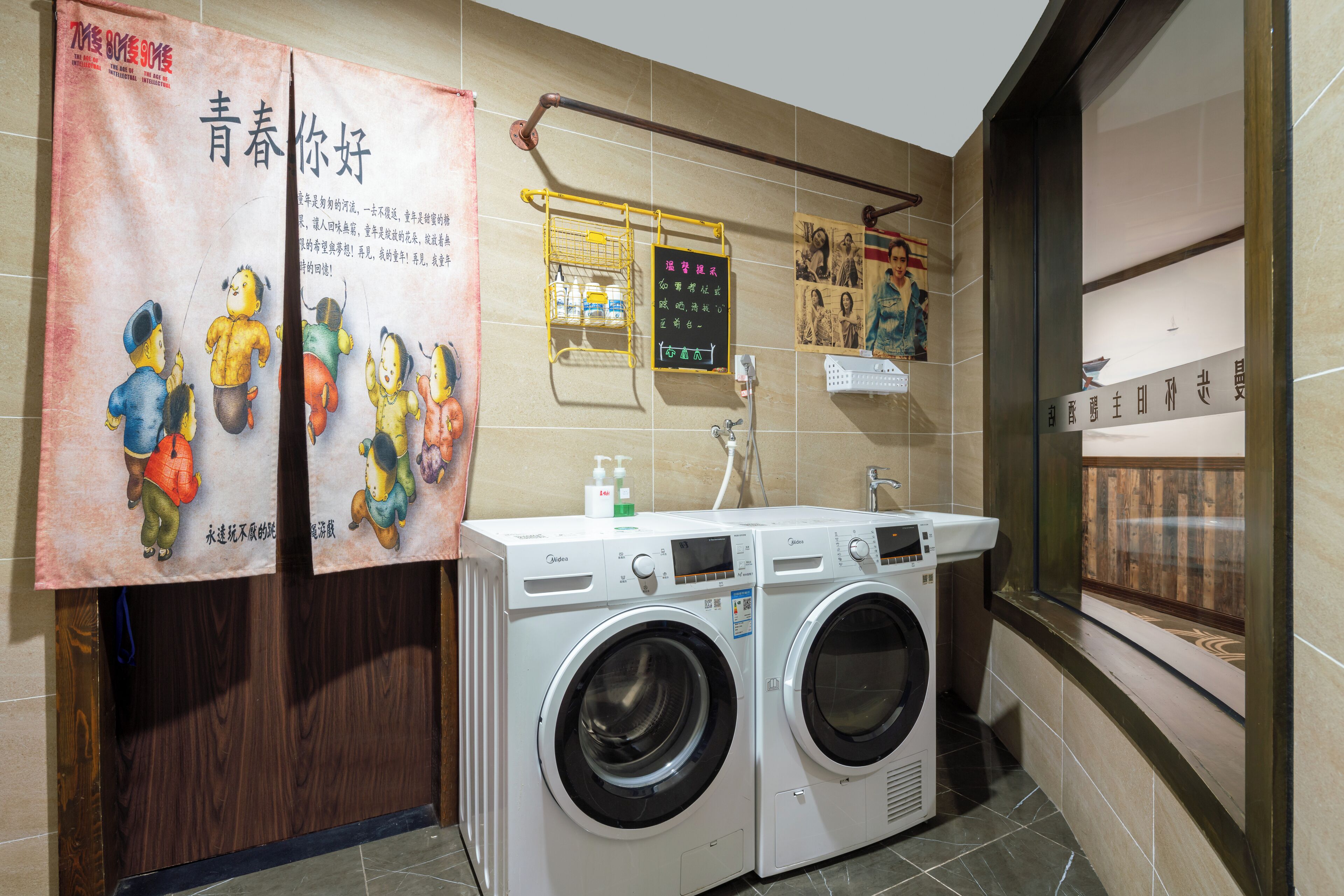 A laundry area with two front-loading washing machines, a small shelf with toiletries, and a wall-mounted drying rack.