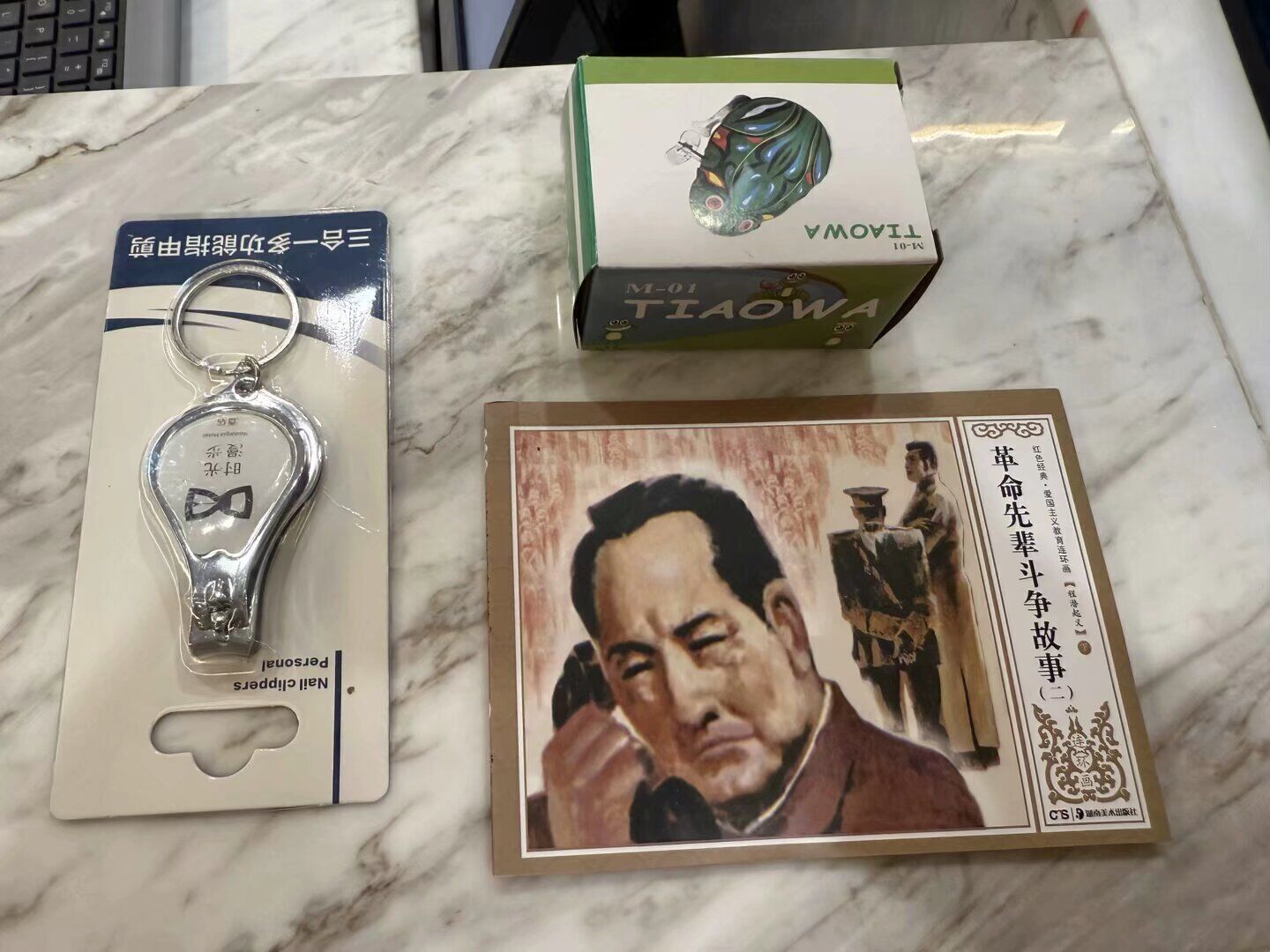 A marble table with a keychain, a box labeled "Tiaowa," and a framed picture.