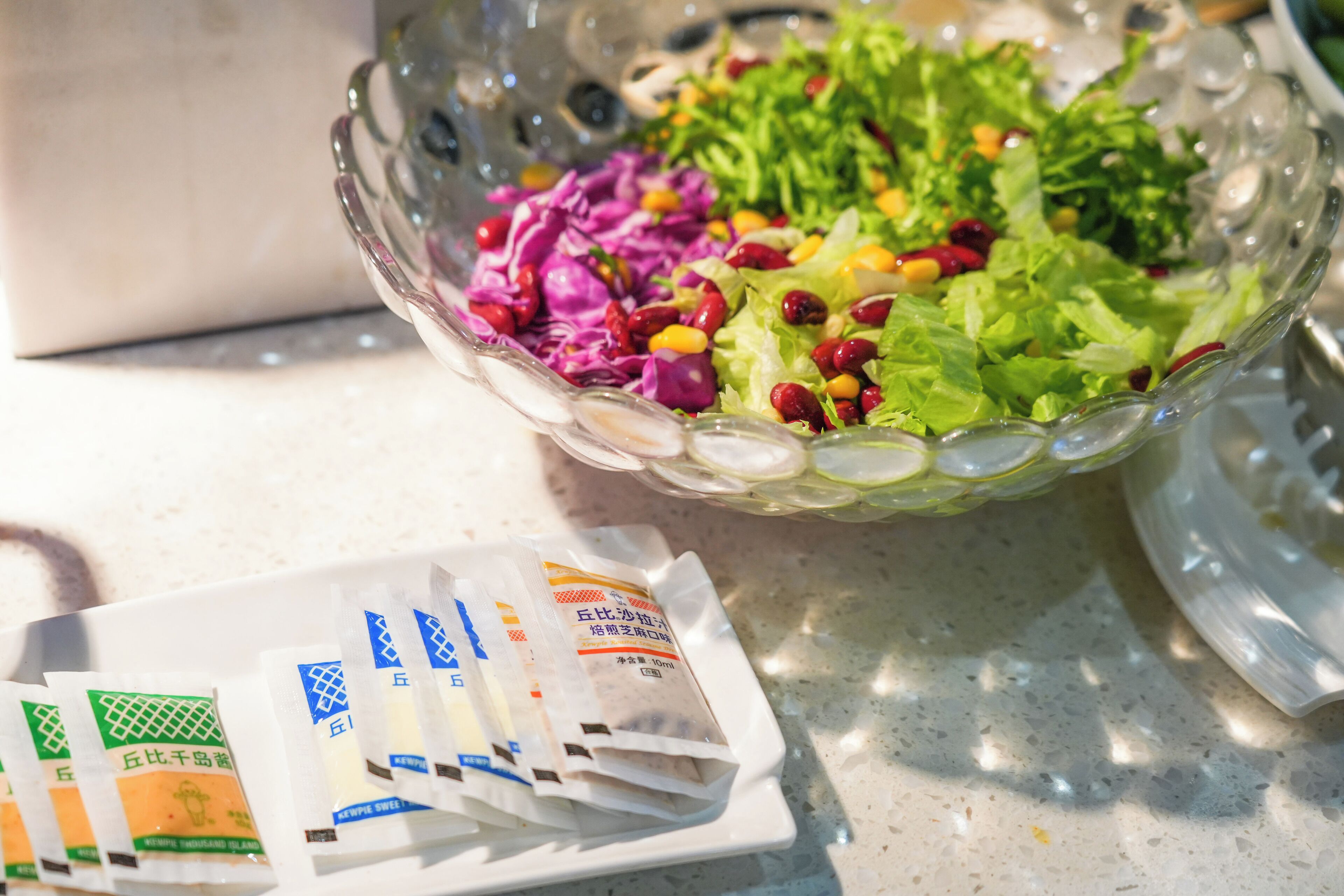 A glass bowl filled with a salad on a table.