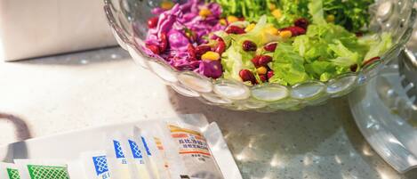 A glass bowl filled with a salad on a table.