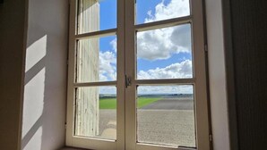 Een uitzicht op een groen veld en een bewolkte lucht.