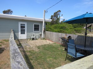 A backyard with a barbecue grill, a wooden deck, and a covered patio area. - Summer Special/RIGHT ACROSS from OCEAN/Fenced yard/pet friendly  (Nags Head)