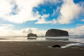 A beach with large rock formations and a clear sky.