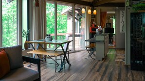 Une cuisine moderne dotée de grandes fenêtres, un coin repas avec une table et des bancs, et un comptoir de cuisine bien visible.