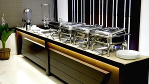 Een buffetopstelling met meerdere bedieningspunten, een koffieapparaat en een waterdispenser.
