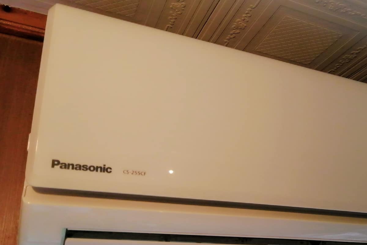 Un equipo de aire acondicionado Panasonic blanco con panel de control.