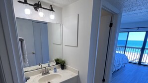 Un baño moderno con un espejo grande, dos lavamanos y una planta en maceta.