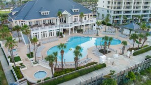 A resort with a large pool, multiple lounge areas, and a multi-story building with balconies. - Gulf Front Beach Club - Renovated Corner Condo, Direct Gulf Views! Pool, WIFI (Gulf Shores)