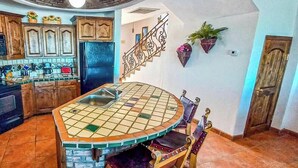 A kitchen with a tiled island, wooden cabinets, and a built-in refrigerator.