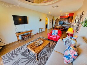Relax in this stylish living room with a flat-screen TV, comfortable sofa, and a cozy armchair.