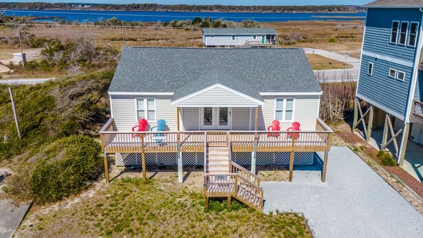 A beachfront house with a covered deck and a small staircase leading to the entrance. - Bella Beach House | Pet Friendly + Beach Access! (North Topsail Beach)