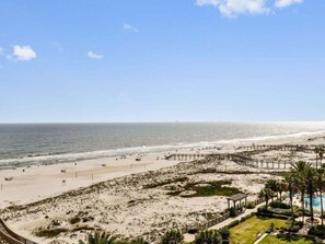 Un complexe hôtelier de bord de mer doté d’une promenade en bois, d’un espace piscine et d’une plage de sable.