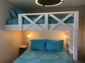 A bunk bed with a lower sleeping area and a loft bed above.
