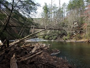 A rustic wooden bridge over a river, surrounded by dense forest and fallen logs. - New Remodel, Enjoy the Cool Mountain Air, Sling, WiFi, Fire Pit, Doggie (Cherry Log)