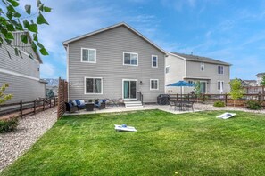 Un immeuble résidentiel de deux étages doté d’un patio couvert, d’une petite pelouse et d’une clôture en bois.
